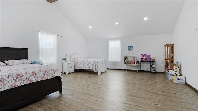 bedroom with hardwood / wood-style flooring and high vaulted ceiling