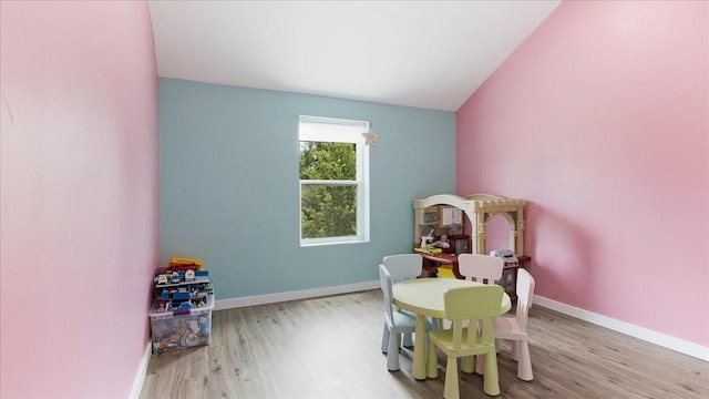 rec room featuring light hardwood / wood-style flooring and vaulted ceiling