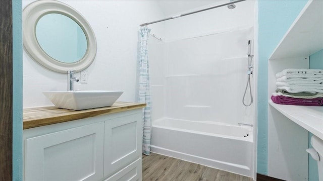 bathroom featuring hardwood / wood-style floors, vanity, and shower / bath combination with curtain