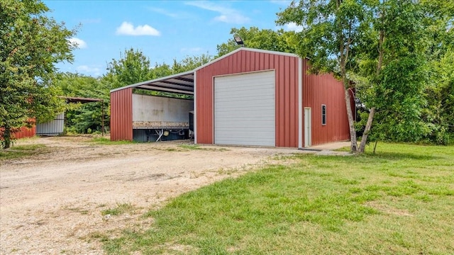 garage featuring a carport and a lawn