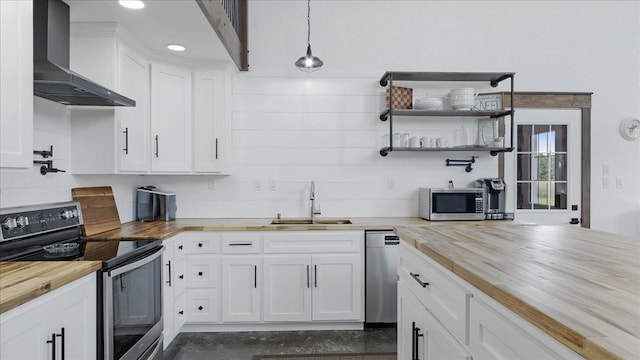 kitchen featuring white cabinets, decorative light fixtures, butcher block counters, and appliances with stainless steel finishes