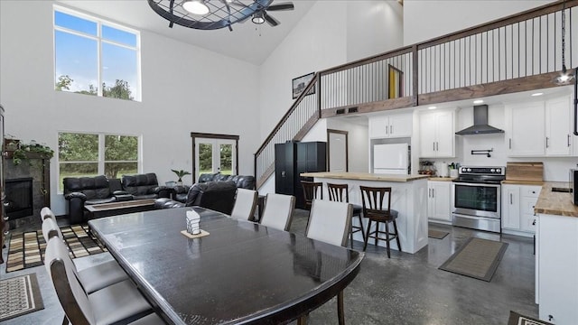 dining area featuring ceiling fan and high vaulted ceiling