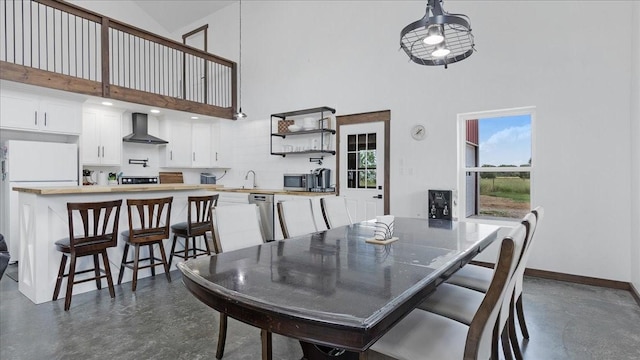 dining area featuring sink and a high ceiling