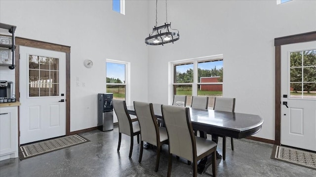 dining space with plenty of natural light and a high ceiling