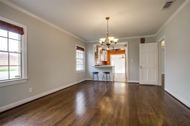 interior space with crown molding, a healthy amount of sunlight, ceiling fan with notable chandelier, and dark wood-type flooring