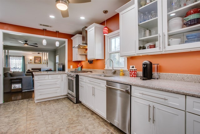 kitchen featuring sink, appliances with stainless steel finishes, hanging light fixtures, light stone counters, and white cabinets