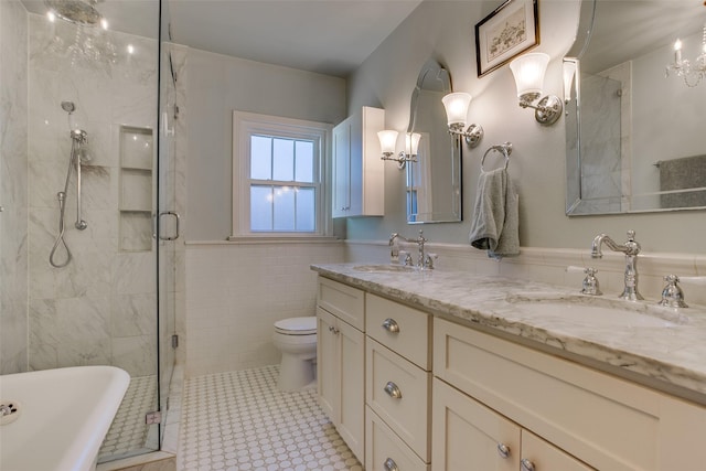 full bathroom with toilet, shower with separate bathtub, tile walls, vanity, and tile patterned flooring