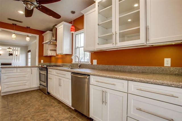 kitchen featuring sink, white cabinetry, light stone counters, appliances with stainless steel finishes, and pendant lighting