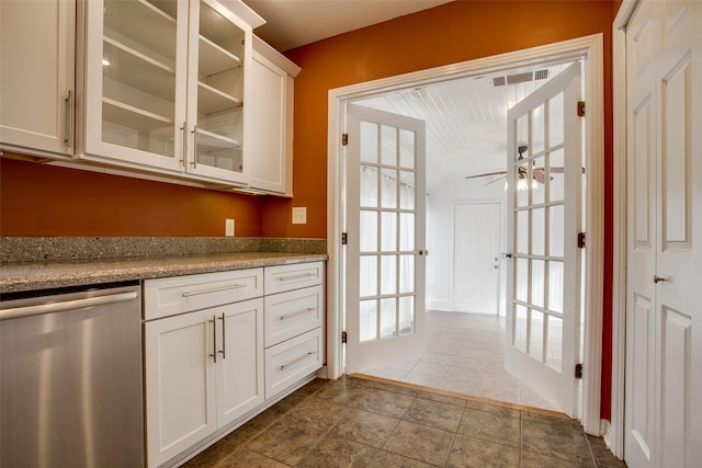 kitchen with white cabinets, light stone countertops, dishwasher, and ceiling fan