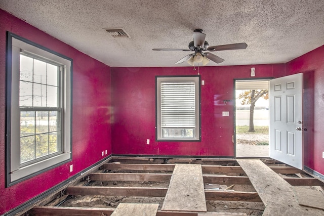 foyer entrance with ceiling fan, plenty of natural light, and a textured ceiling