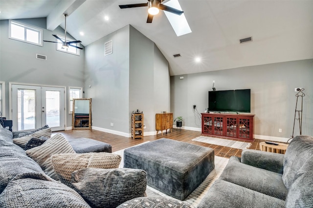 living room with beamed ceiling, ceiling fan, wood-type flooring, and french doors