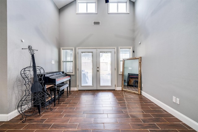 foyer entrance with french doors, a wealth of natural light, and a high ceiling