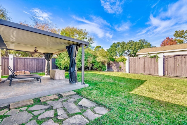 view of yard featuring ceiling fan and a patio