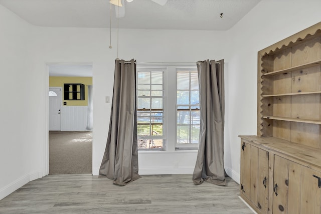 interior space with ceiling fan, light hardwood / wood-style floors, and a textured ceiling