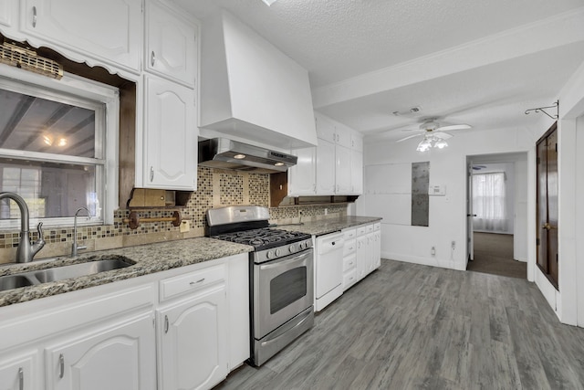 kitchen featuring wall chimney exhaust hood, a textured ceiling, stainless steel appliances, sink, and white cabinets