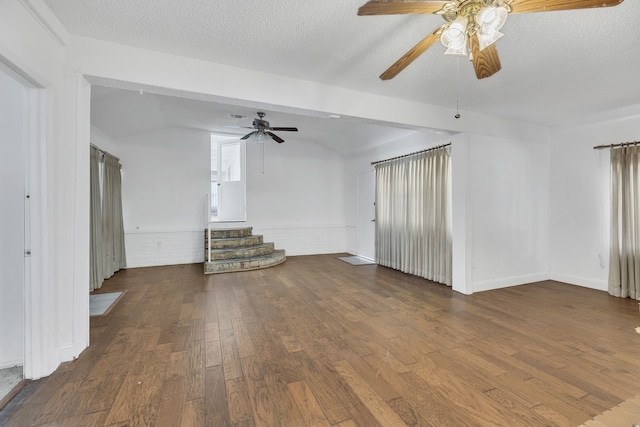 unfurnished living room featuring a textured ceiling, dark wood-type flooring, and vaulted ceiling