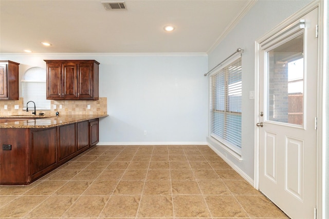 kitchen featuring sink, tasteful backsplash, light stone counters, light tile patterned floors, and ornamental molding