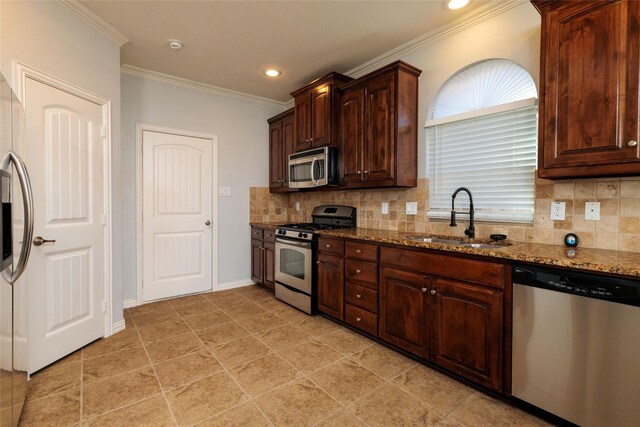 kitchen with stone counters, sink, stainless steel appliances, backsplash, and ornamental molding