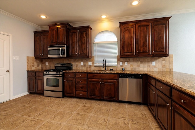 kitchen with tasteful backsplash, light stone counters, sink, and appliances with stainless steel finishes