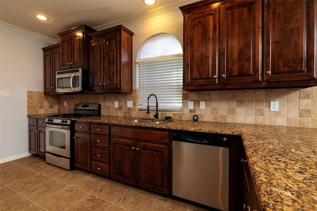 kitchen with tasteful backsplash, light stone counters, sink, and appliances with stainless steel finishes