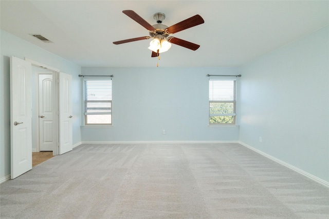 spare room featuring ceiling fan and light carpet