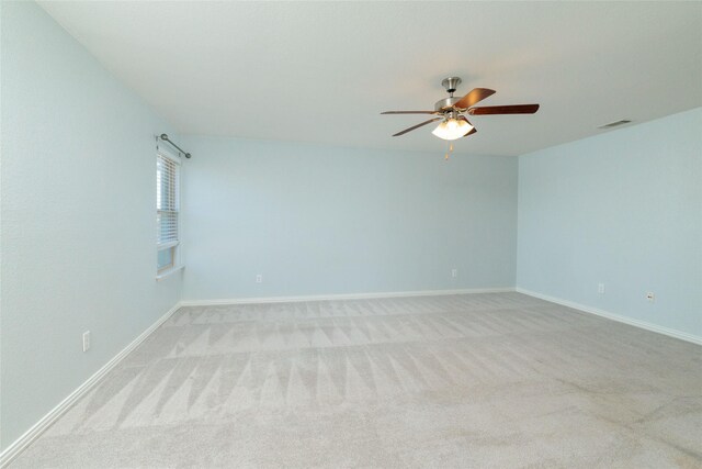 spare room featuring ceiling fan and light carpet