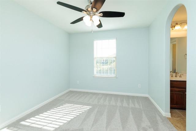 carpeted spare room with ceiling fan and sink