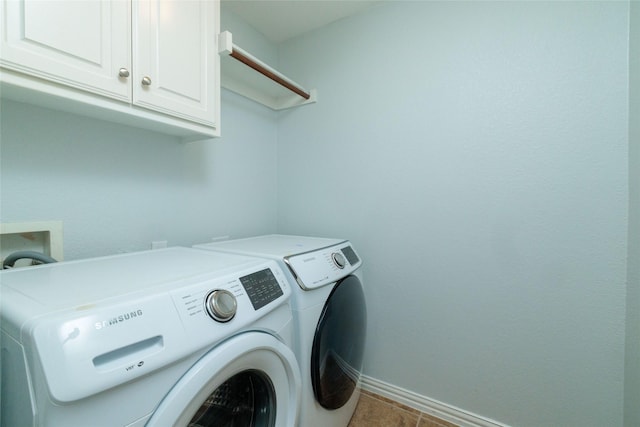 washroom featuring cabinets, light tile patterned floors, and washing machine and dryer