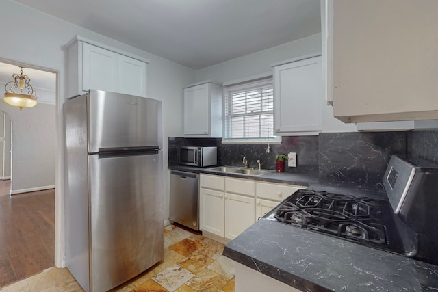 kitchen with backsplash, white cabinetry, sink, and appliances with stainless steel finishes