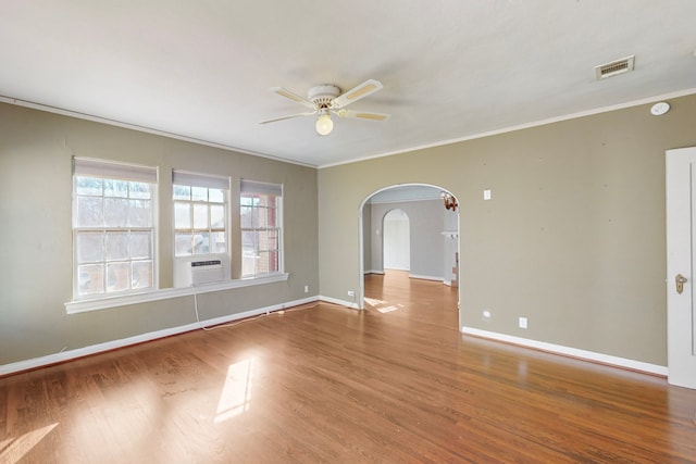 spare room featuring hardwood / wood-style floors, cooling unit, ceiling fan, and ornamental molding