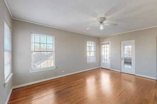 empty room with ceiling fan, wood-type flooring, crown molding, and a wealth of natural light