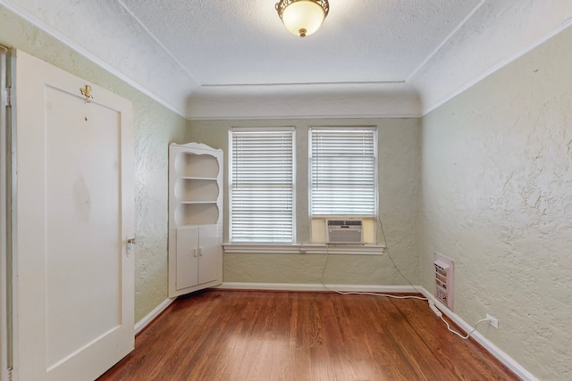 spare room featuring dark hardwood / wood-style floors, cooling unit, and a textured ceiling