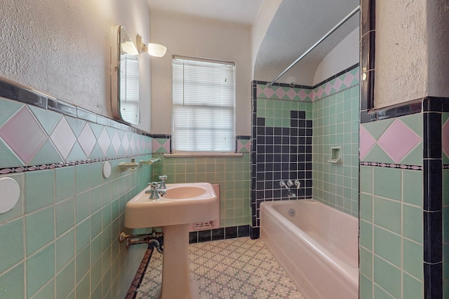 bathroom featuring tile walls and tiled shower / bath