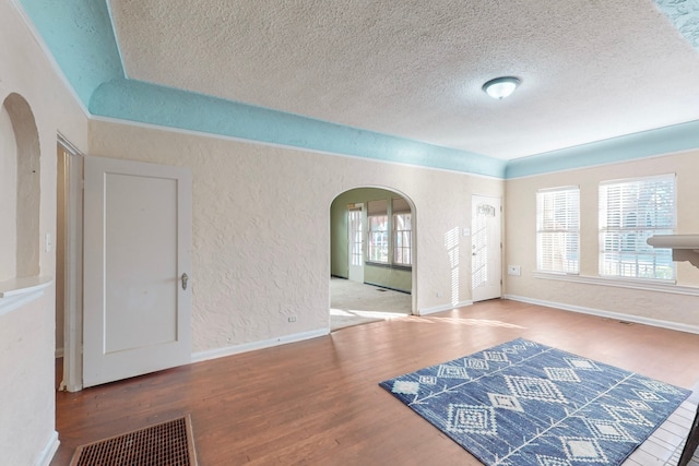 foyer entrance with hardwood / wood-style floors and a textured ceiling