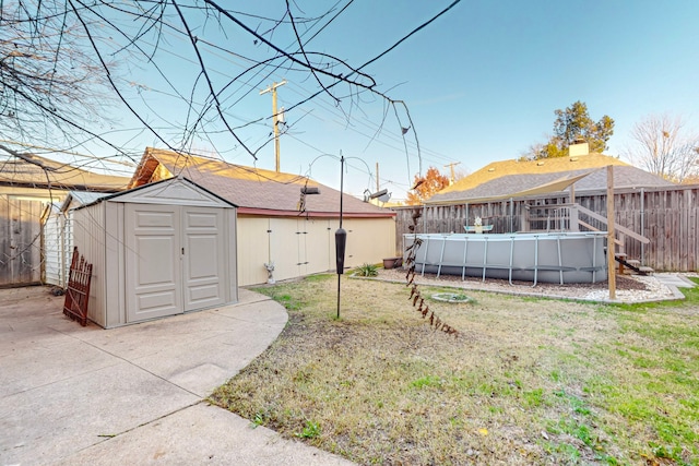 view of yard featuring a storage unit, a patio area, and a fenced in pool