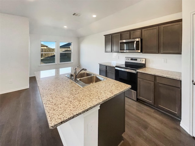 kitchen featuring sink, stainless steel appliances, light stone countertops, a center island with sink, and dark hardwood / wood-style flooring