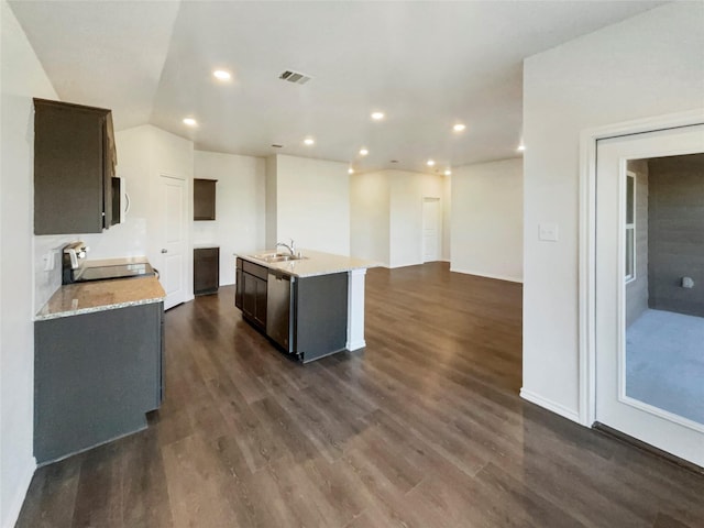 kitchen with a kitchen island with sink, stove, dark hardwood / wood-style floors, light stone counters, and stainless steel dishwasher