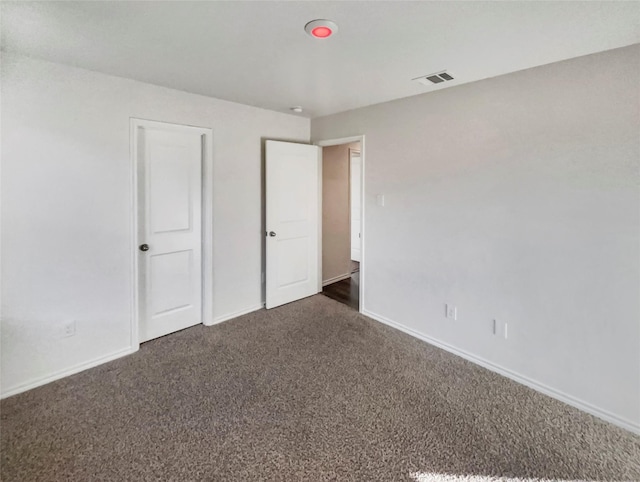 unfurnished bedroom with dark colored carpet