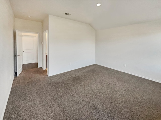 empty room with vaulted ceiling and dark colored carpet