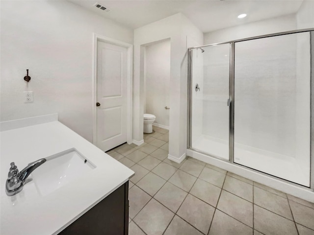 bathroom featuring vanity, tile patterned flooring, a shower with door, and toilet