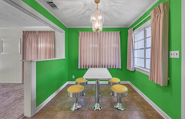 dining space featuring wood walls and ornamental molding