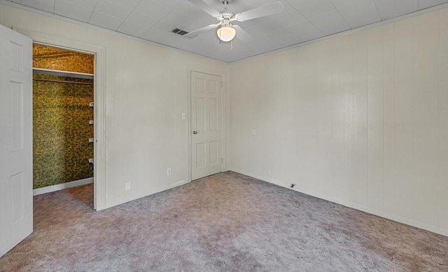 unfurnished bedroom with carpet flooring, a closet, ceiling fan, and ornamental molding