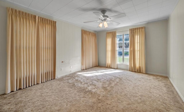 empty room featuring carpet flooring, ceiling fan, and ornamental molding