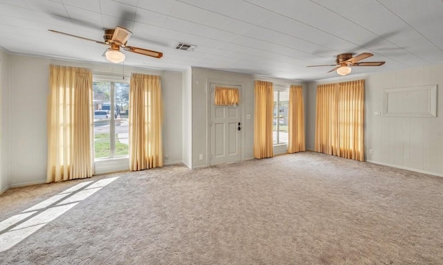 unfurnished living room with carpet flooring, plenty of natural light, and ceiling fan