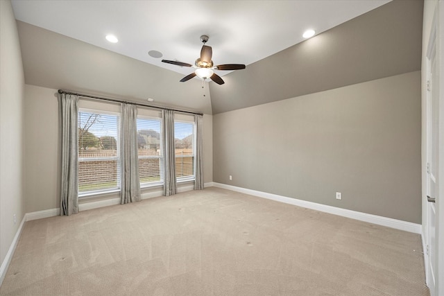 spare room featuring ceiling fan, light colored carpet, and lofted ceiling