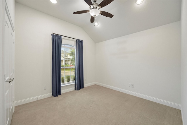 empty room featuring light colored carpet, ceiling fan, and lofted ceiling