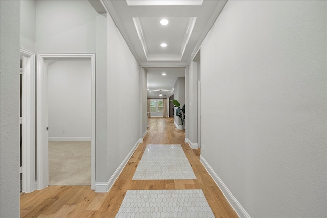 hall with a tray ceiling and light hardwood / wood-style floors