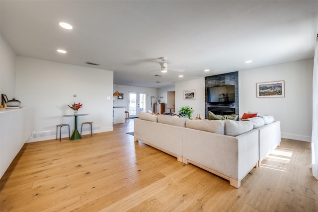 living room with light hardwood / wood-style flooring and ceiling fan