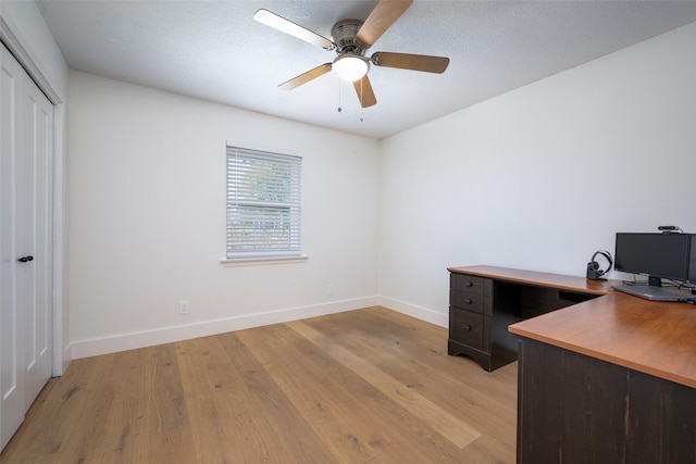 unfurnished office featuring ceiling fan, light hardwood / wood-style flooring, and a textured ceiling