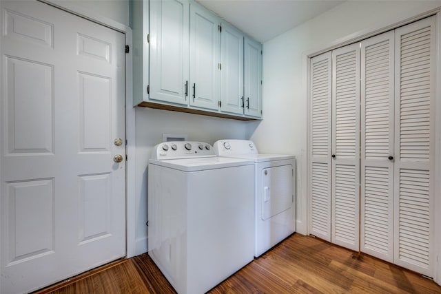 laundry room with cabinets, washing machine and dryer, and hardwood / wood-style flooring